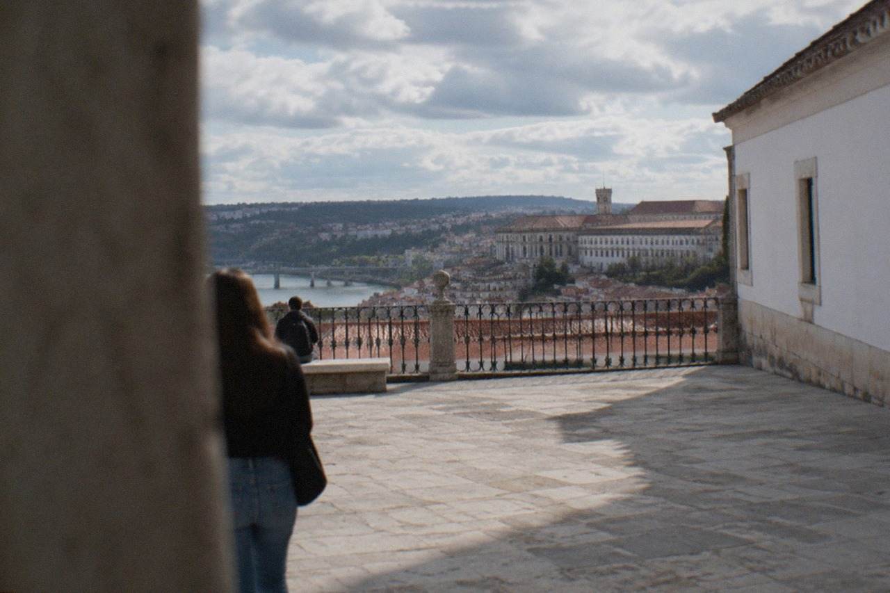 The University of Coimbra buildings and the city rooftops seen from the upper town on a bright afternoon