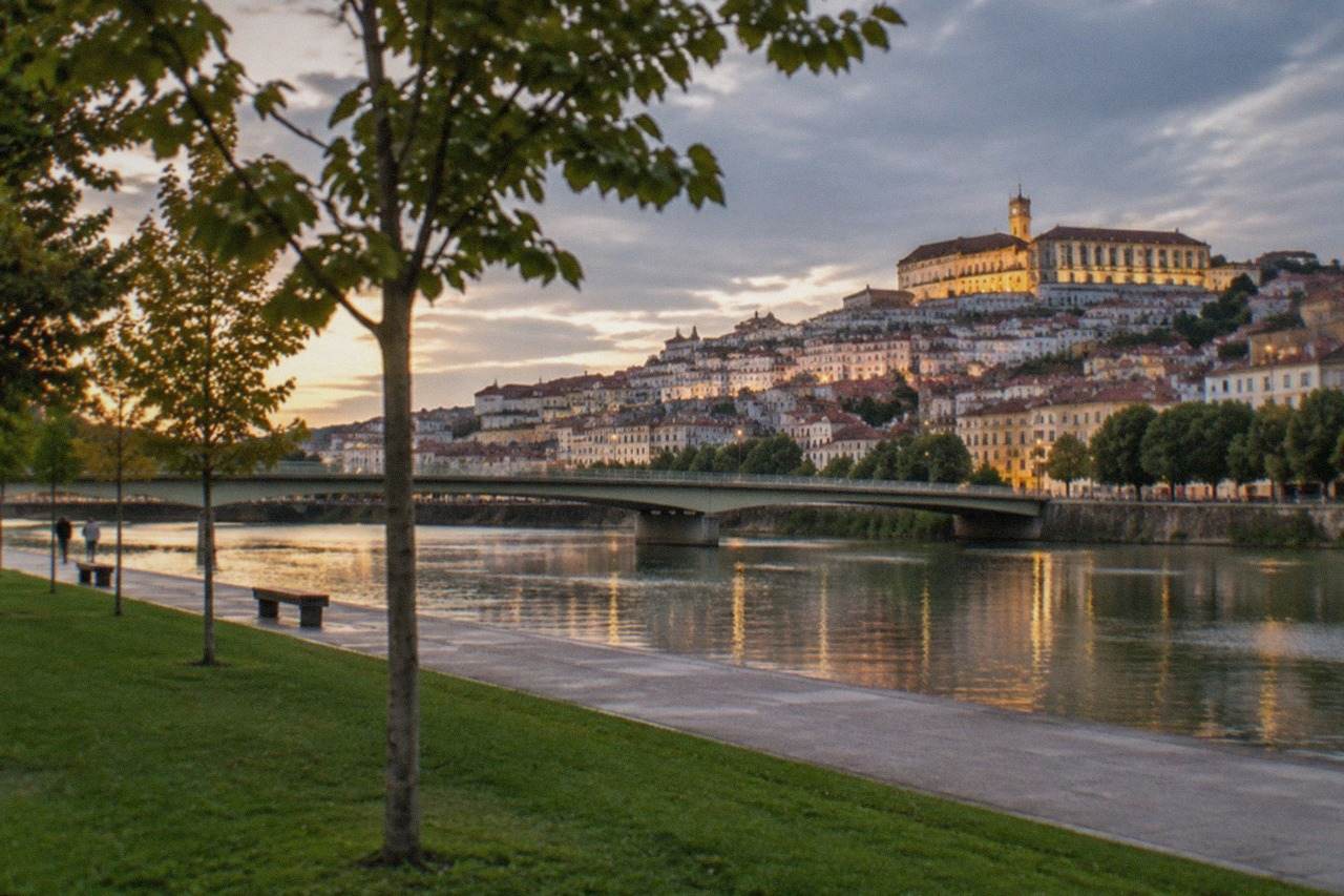 Evening view over the illuminated old city of Coimbra with the university buildings lit above the River Mondego
