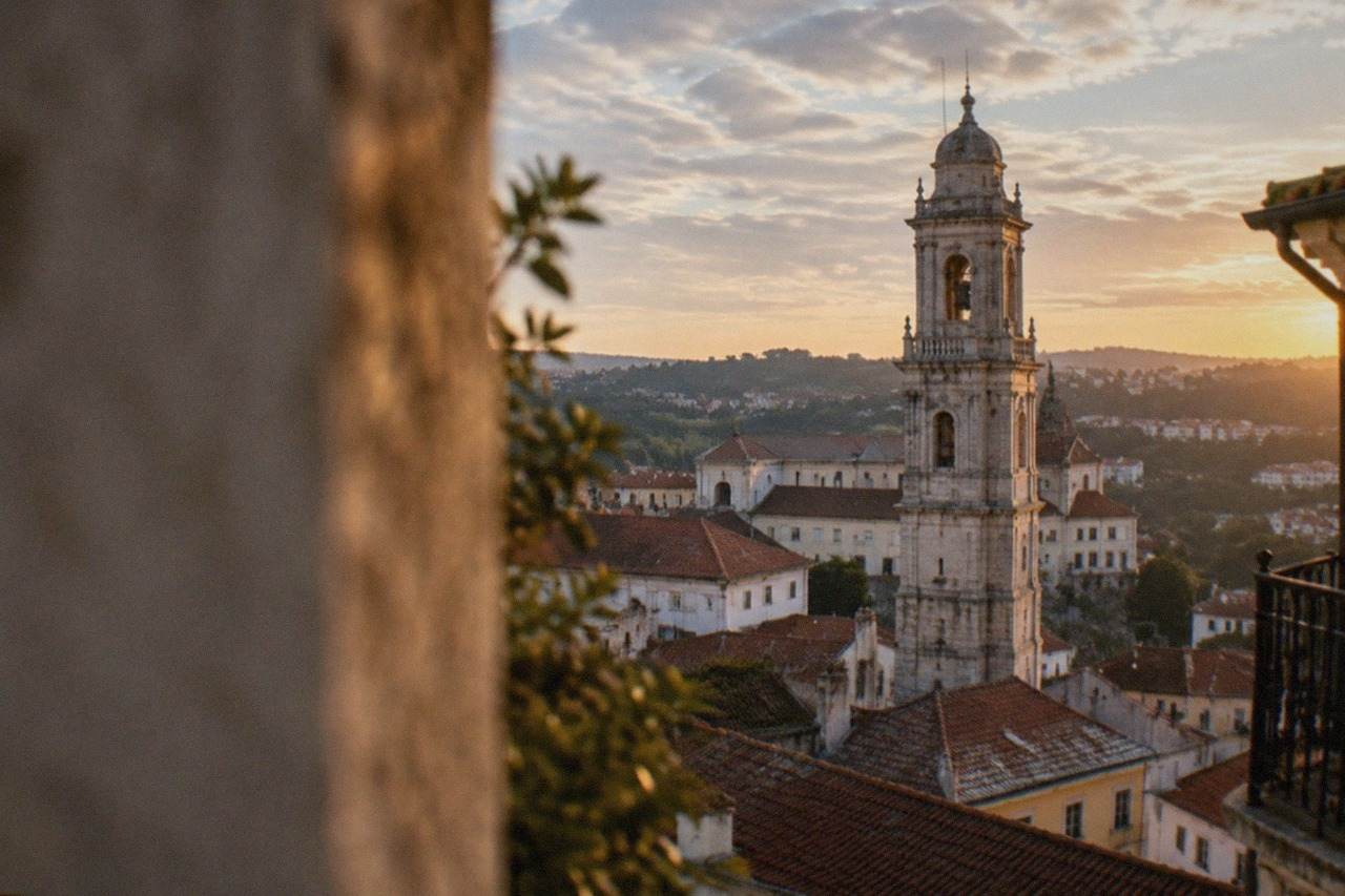 View over the old town of Coimbra, Portugal, with the university tower above red rooftops