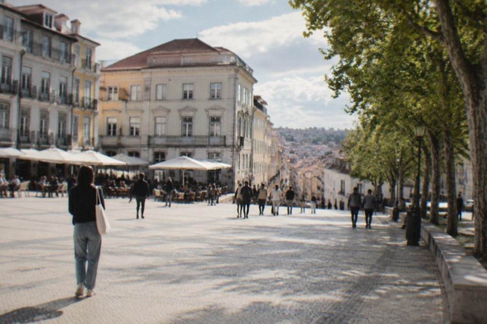 Visitors walking through the narrow streets of Coimbra's old town below the university hill