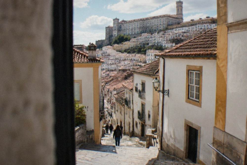 The stone facade and terrace of Coimbra University on the hill above the old town rooftops