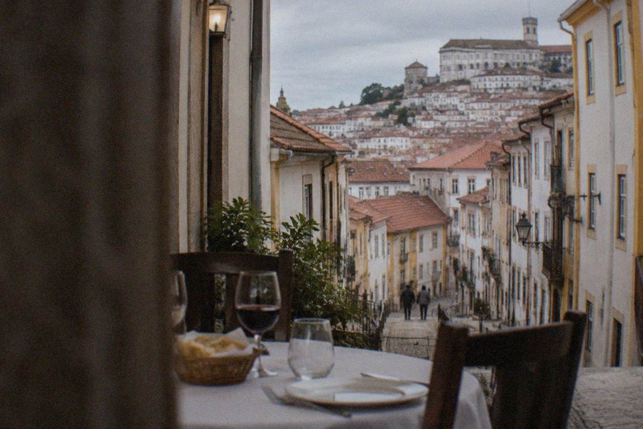A table set for dinner in a traditional Coimbra restaurant with bread, wine glasses and a white tablecloth