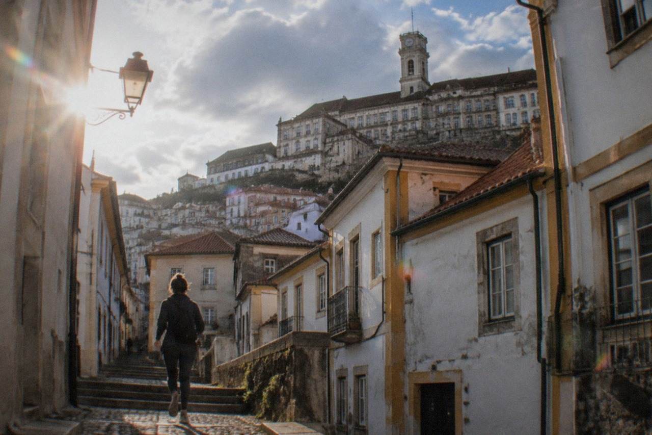 The historic university buildings of Coimbra seen from below on a bright afternoon