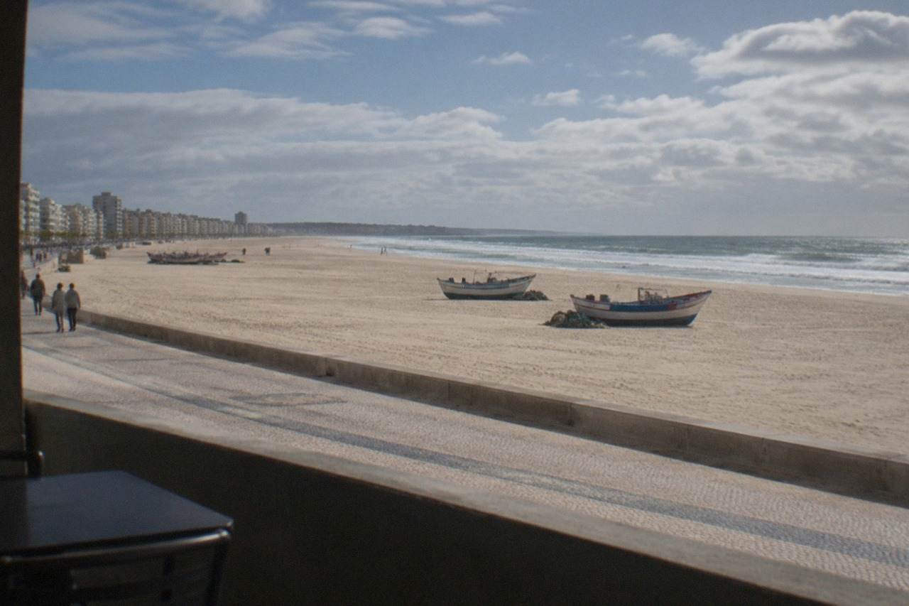 Wide view over a Portuguese coastal town with a long sandy beach and fishing boats