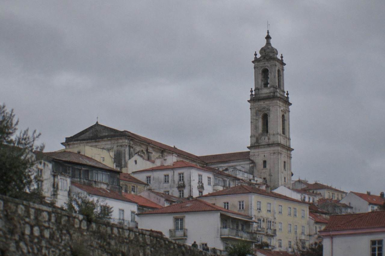The university tower and old town rooftops of Coimbra seen from below