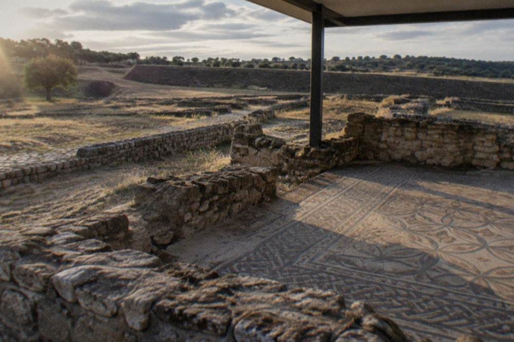 A stone-paved Roman walkway lined with low ruined walls at Conimbriga