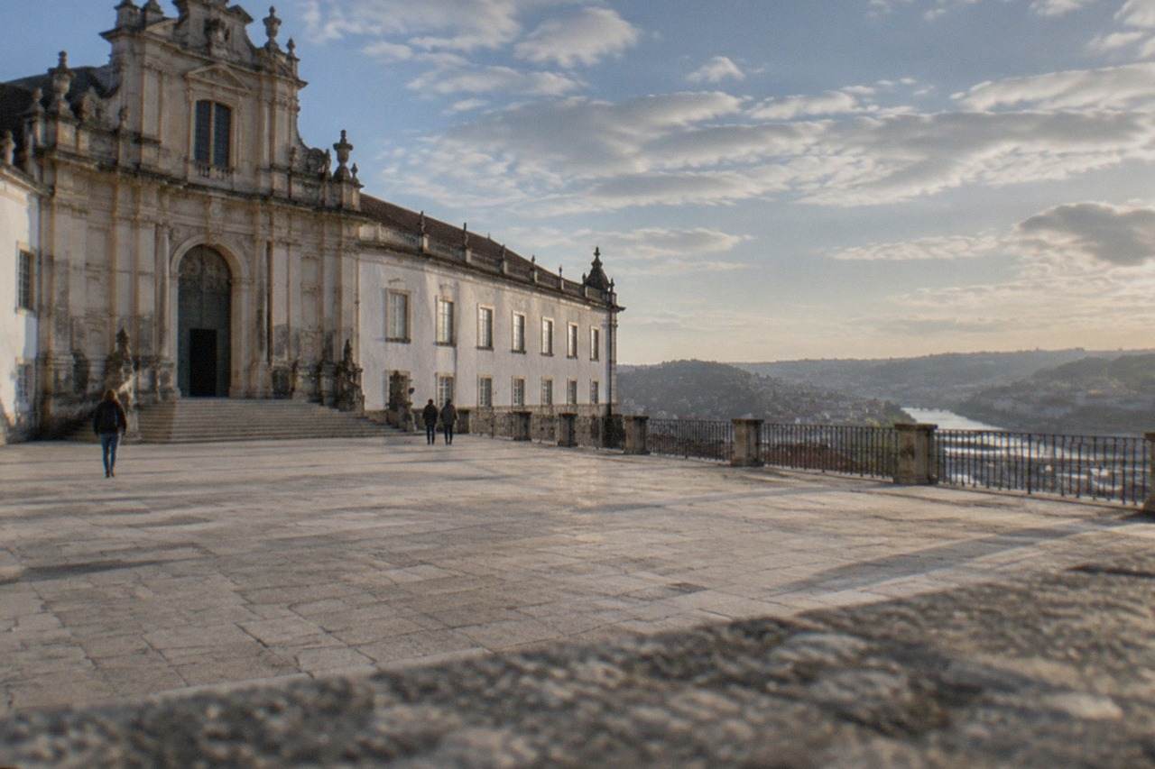 The grand baroque facade and courtyard of the University of Coimbra on its hill above the city