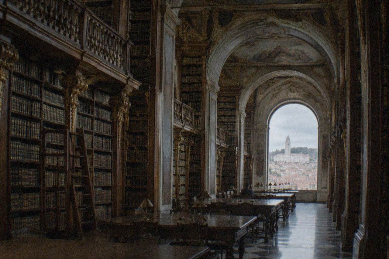 The baroque library tower and university buildings of Coimbra rising above the red rooftops of the old town