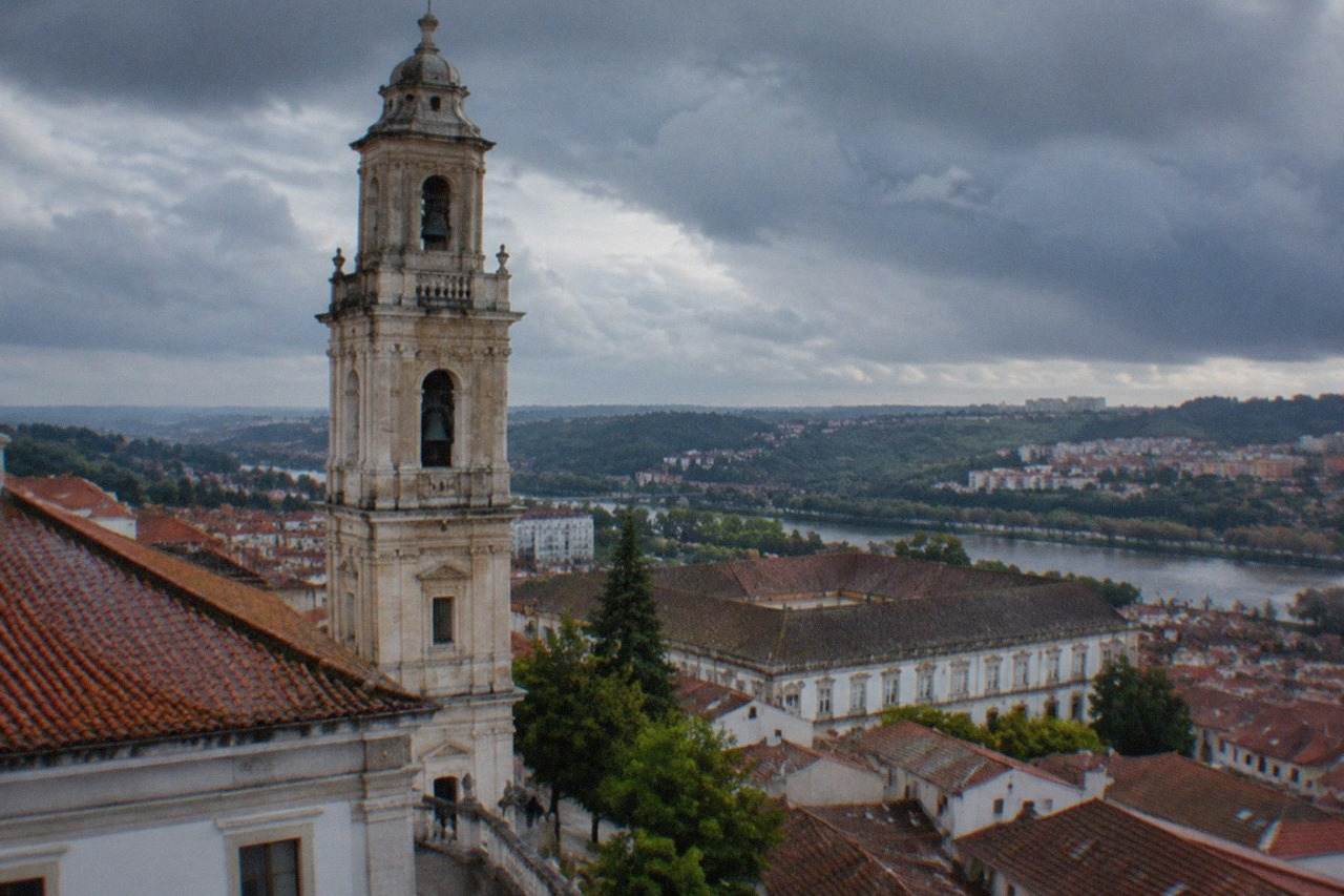 Rain clouds over the rooftops and university tower of Coimbra, Portugal