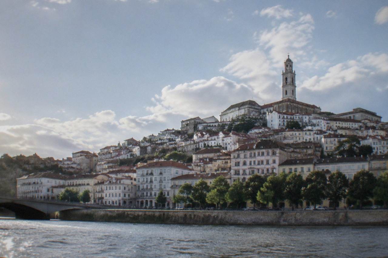 The old city of Coimbra rising above the River Mondego, with the university tower on the hilltop