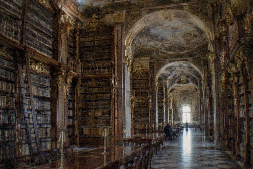 The baroque interior of the Joanina Library, with gilded bookshelves rising between painted ceilings