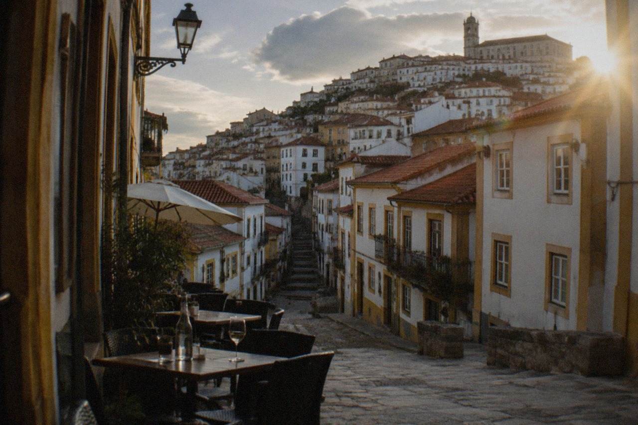 Evening tables set outside on a narrow stone street in Coimbra's old town