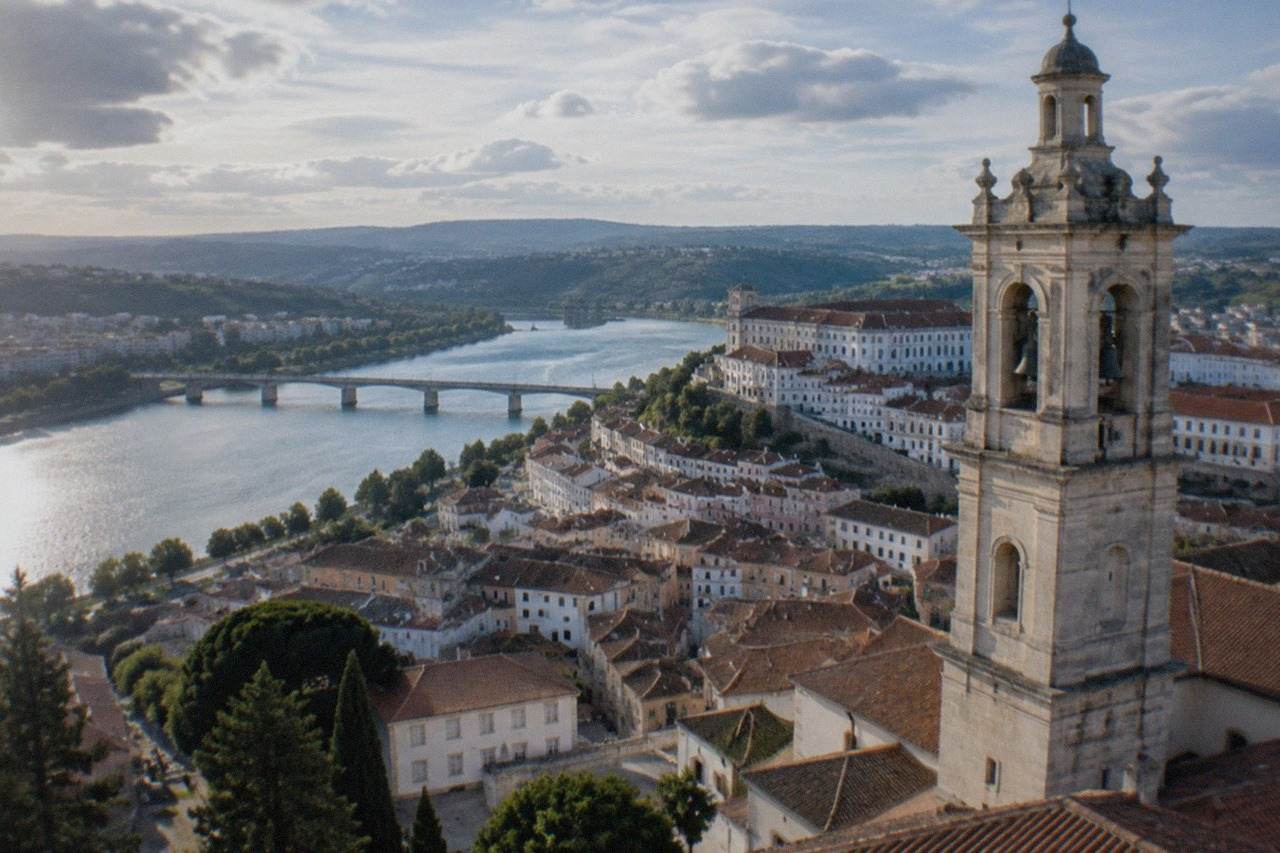 The old town of Coimbra rising above the River Mondego, with the university tower on the hillside