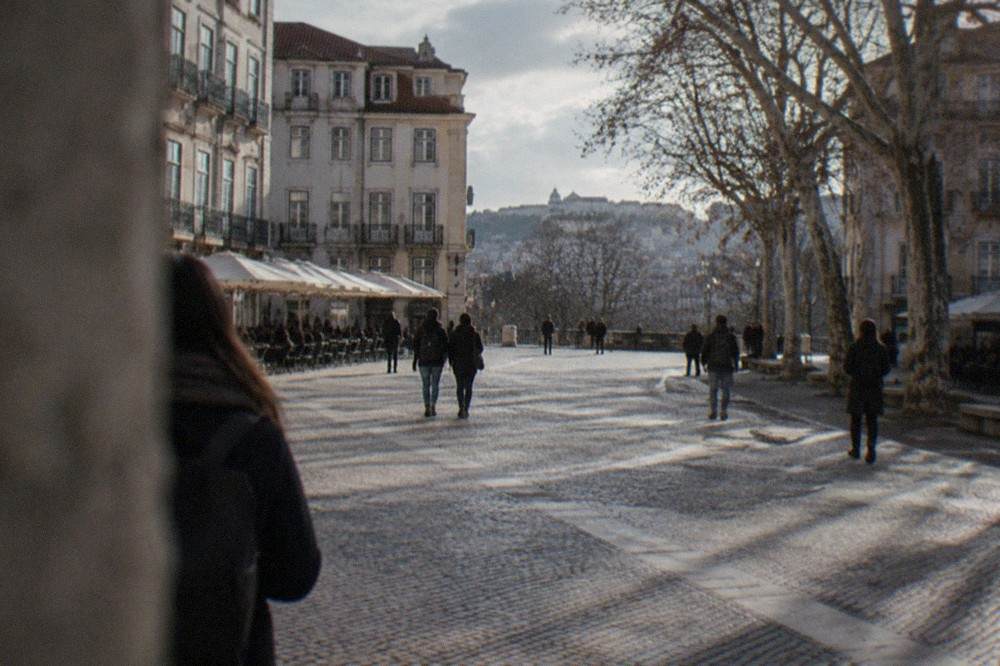 Visitors walking through the cobbled lanes below the university hill in Coimbra
