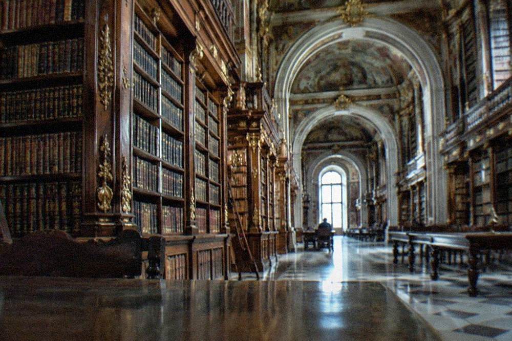 The baroque interior of the Joanina Library with tall wooden bookshelves