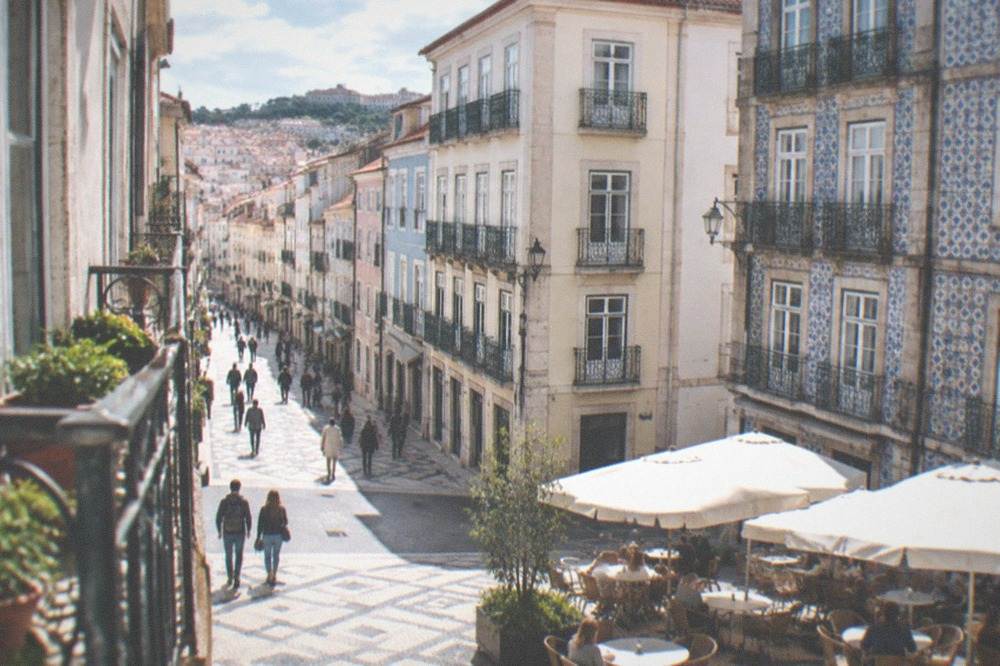 Tables set outside a traditional cafe on a stone-paved square in Coimbra's downtown