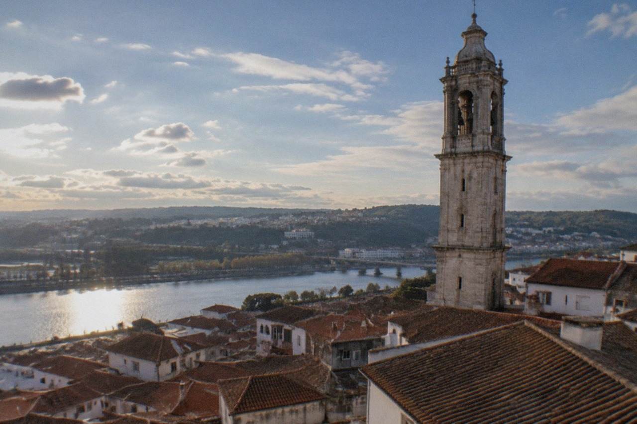 View over the tiled roofs of Coimbra's old town with the university tower rising above the River Mondego