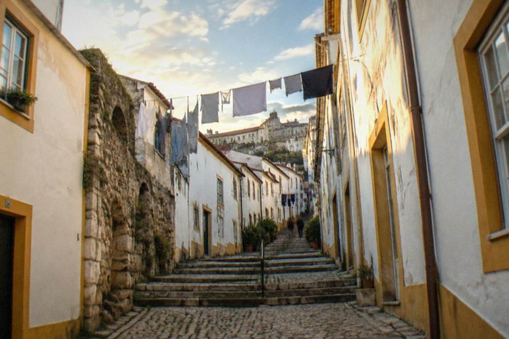 Stepped cobbled lane with old houses climbing toward the upper town of Coimbra