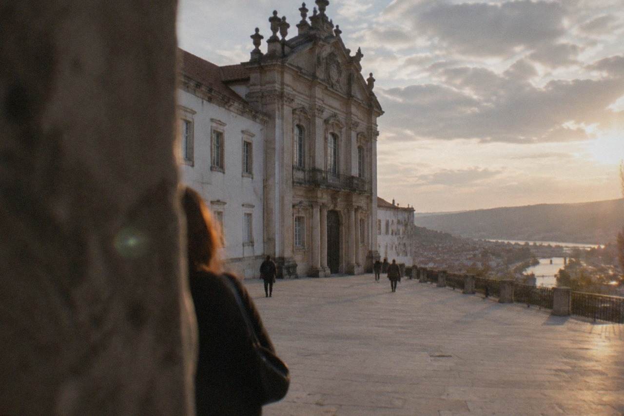 The grand baroque facade of the University of Coimbra overlooking the city rooftops