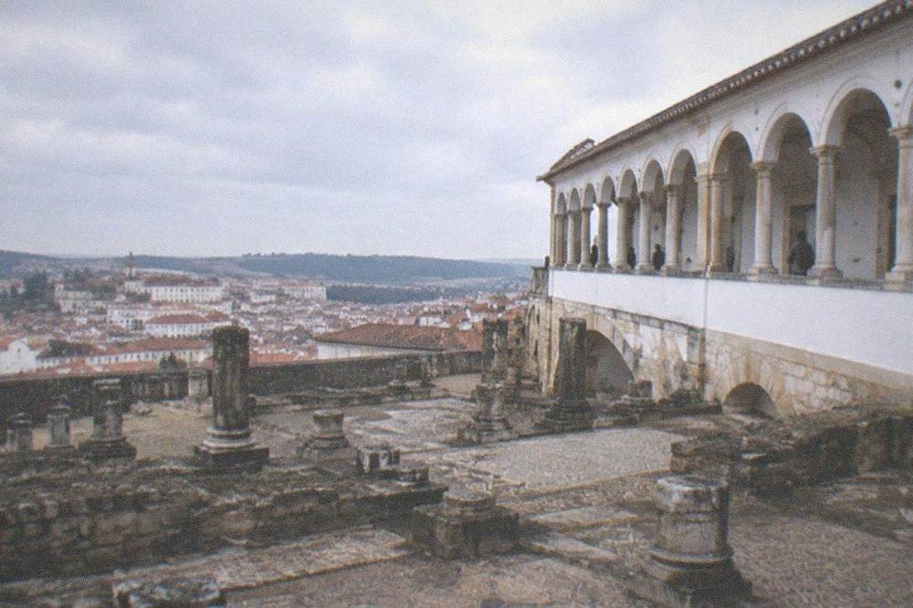 Ancient stone ruins with column bases and mosaic floors under an open sky