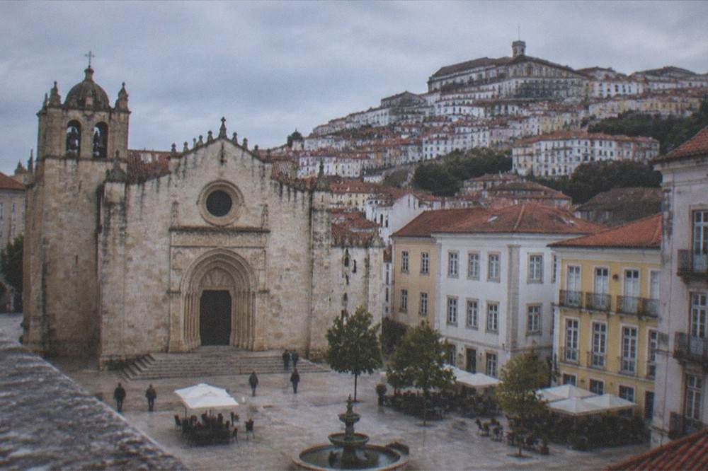 Looking up from the Santa Cruz square toward the hillside lanes of Coimbra's upper town