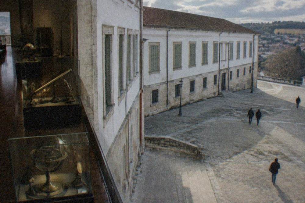 Glass display cases of old scientific instruments arranged in a dimly lit museum gallery