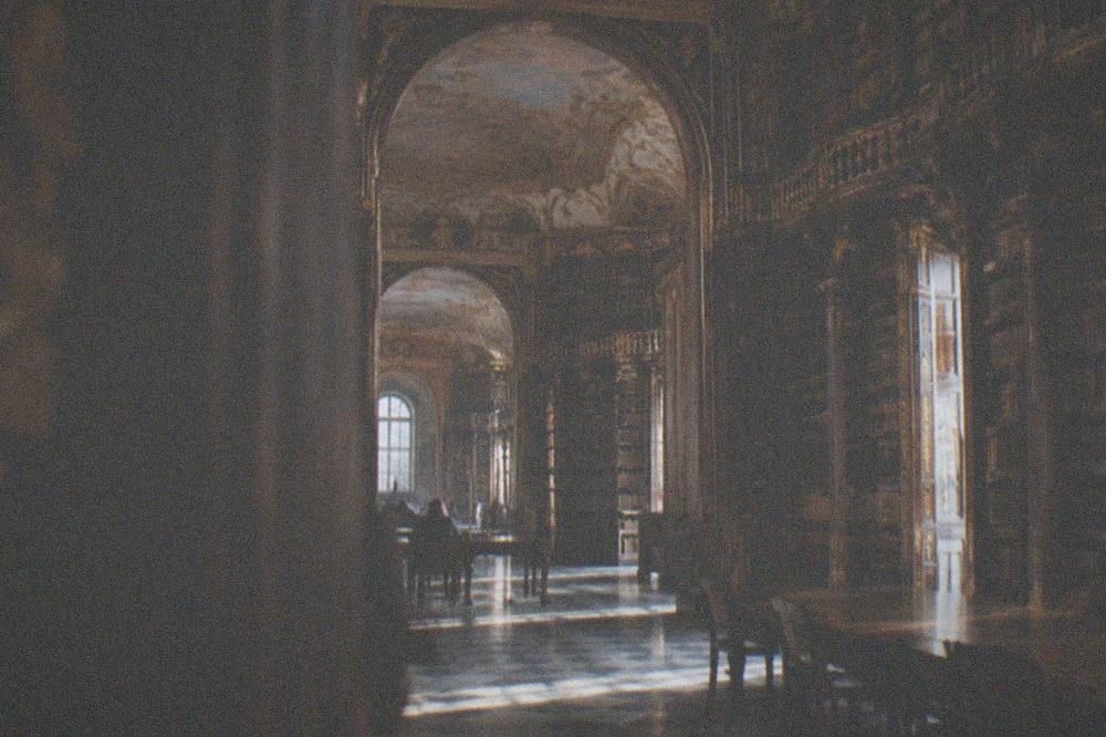 Baroque library hall with gilded bookshelves and painted ceiling inside the Joanina Library