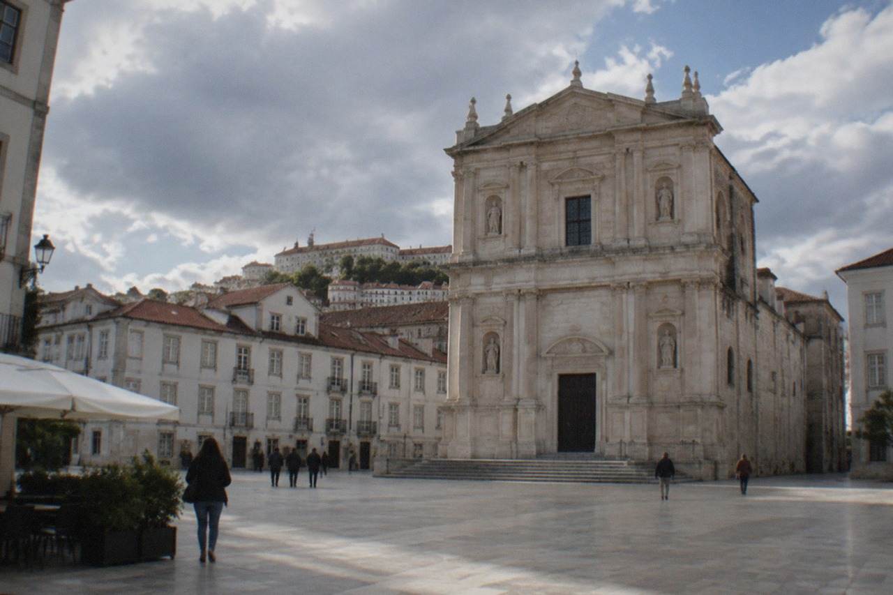 The stone facade of the Sé Nova cathedral rising above the rooftops of Coimbra