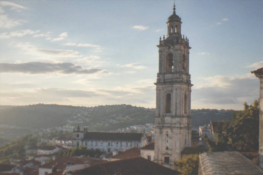 The closed university clock tower rising above the rooftops of the old town