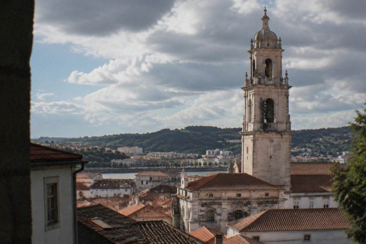 View over the old city of Coimbra, Portugal, with the university tower rising above terracotta rooftops