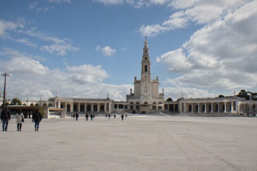 Pilgrims walking the long open esplanade toward the basilica at Fátima
