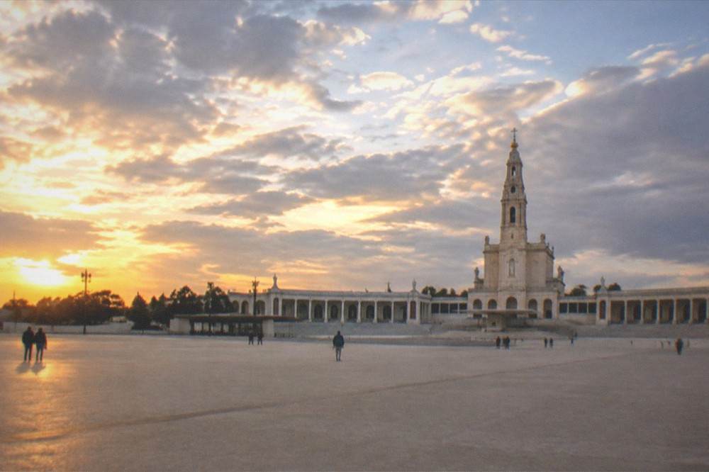 The wide open sanctuary esplanade at golden hour with visitors scattered across it
