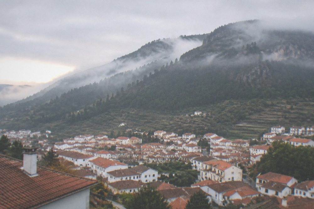 Morning mist rising over forested mountain slopes at sunrise
