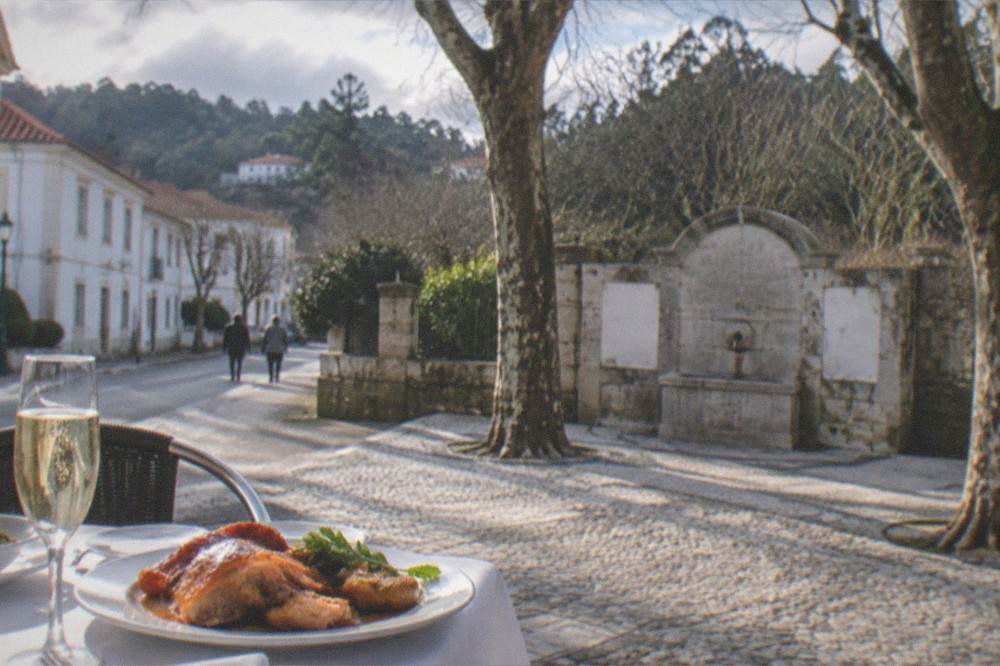 A plate of roast suckling pig with sparkling wine on a restaurant table in Portugal