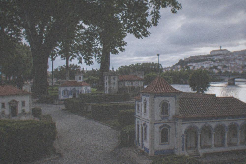The miniature pavilions of Portugal dos Pequenitos seen from a flat walkway on the Santa Clara side of the river