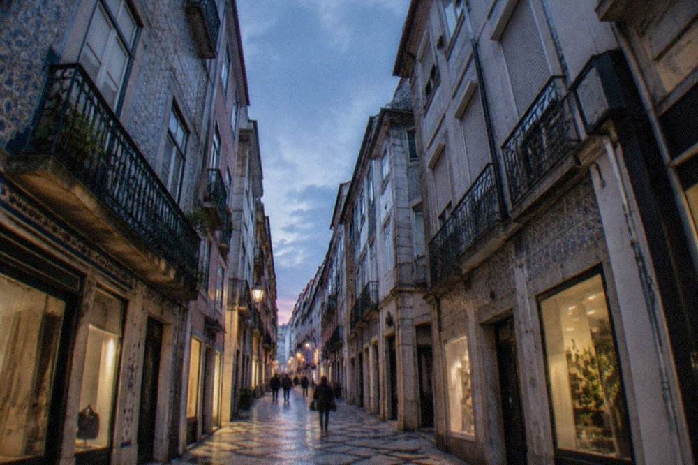 Narrow street in the Baixa lower town of Coimbra with traditional shopfronts and apartment windows