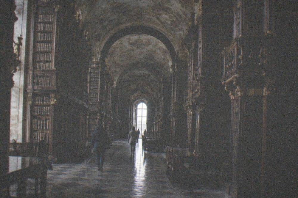 The baroque interior of the Joanina Library with tall wooden bookshelves and a painted ceiling