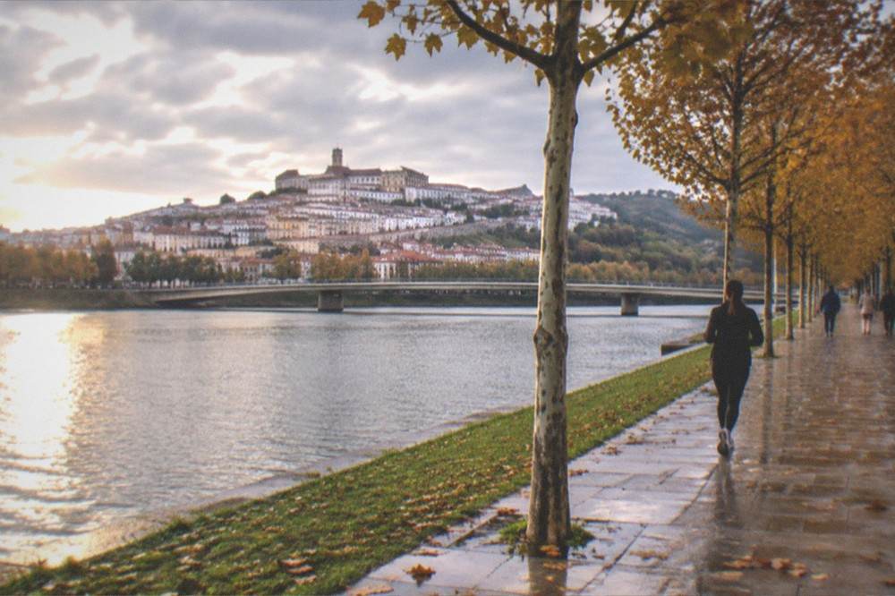 Evening view over the Mondego river and the old town of Coimbra in autumn colours