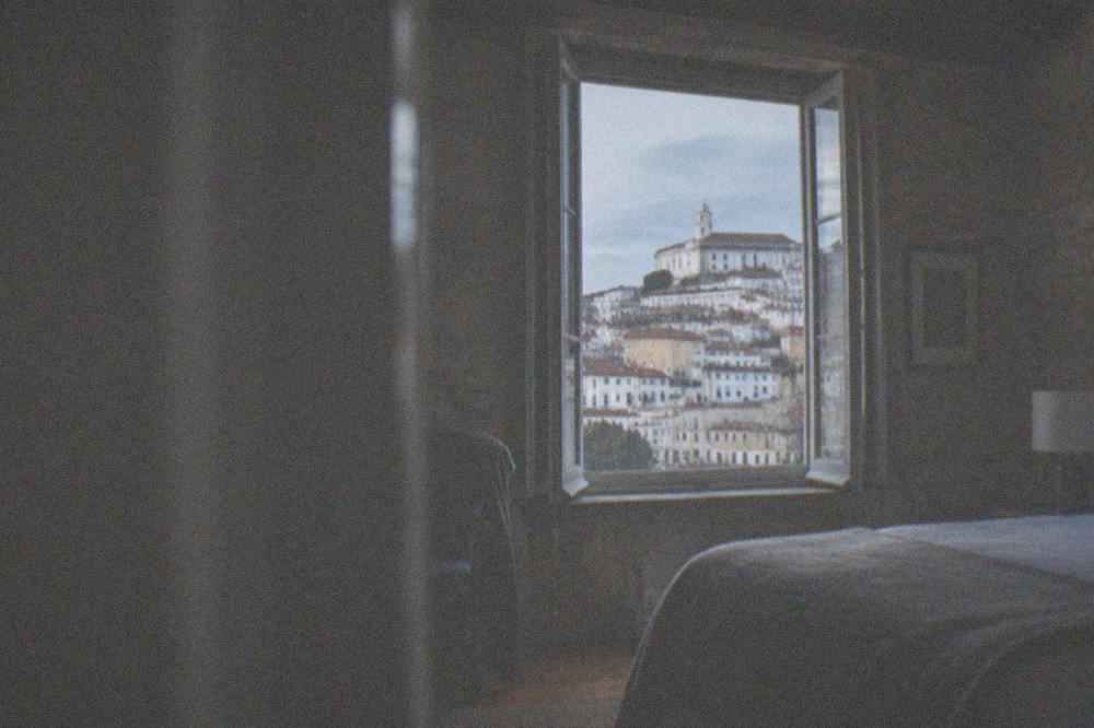 Boutique hotel room in a converted Coimbra townhouse with stone walls and wooden beams