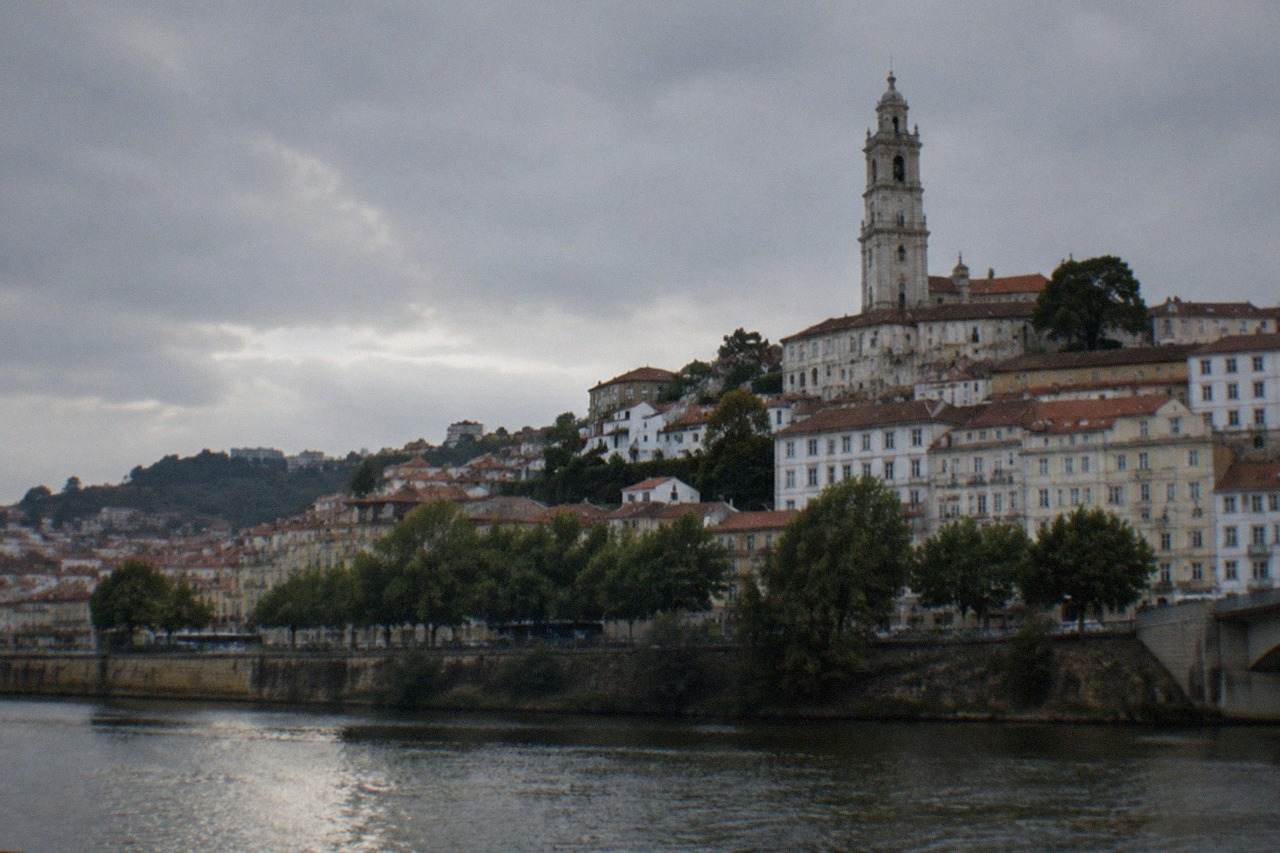 The hillside of Coimbra with the university tower rising above rooftops and the River Mondego below