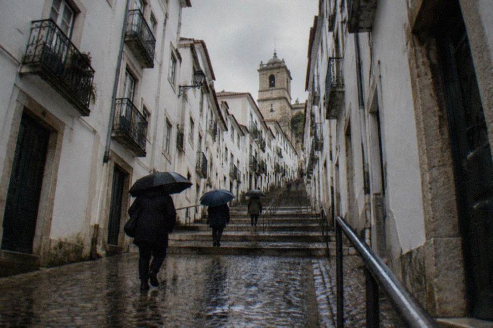 Cobbled lane in Coimbra's upper town with wet stone reflecting winter light