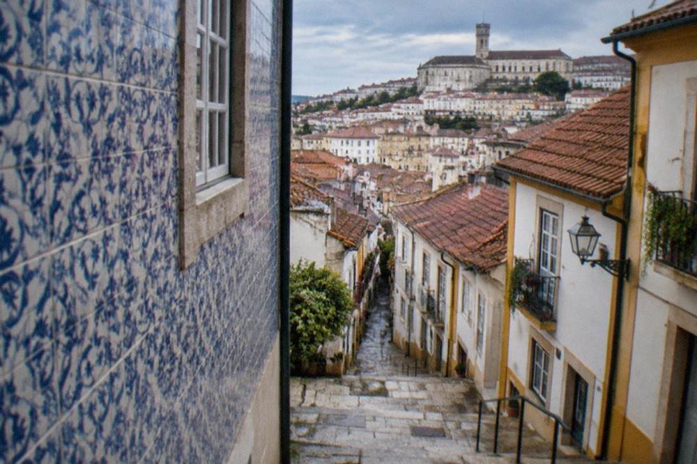 Close view of blue and white patterned ceramic tiles covering a building wall in Coimbra