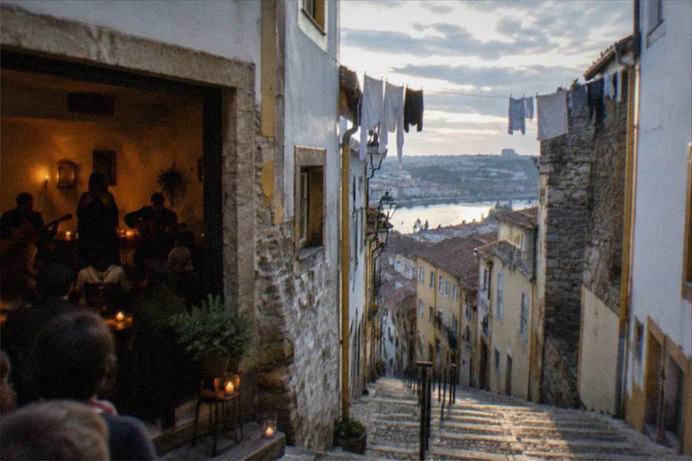 A small candlelit venue where a singer and guitarists perform traditional fado to a seated audience