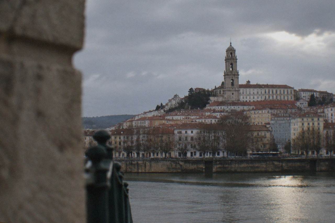 The hillside of Coimbra with the university tower rising above the red rooftops above the River Mondego