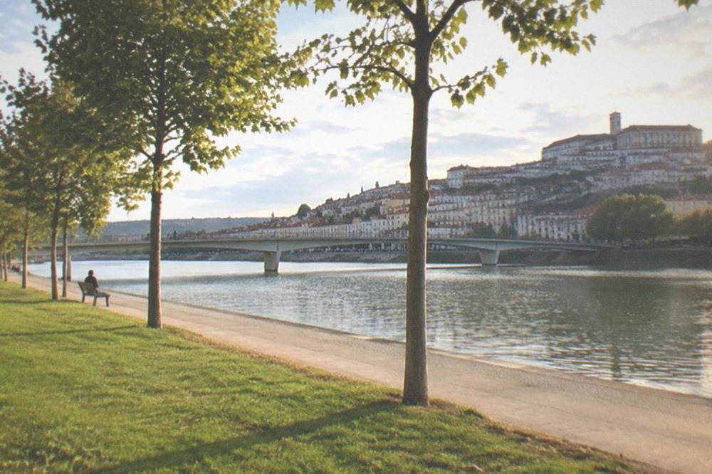 The River Mondego running past the green parkland below Coimbra's old town
