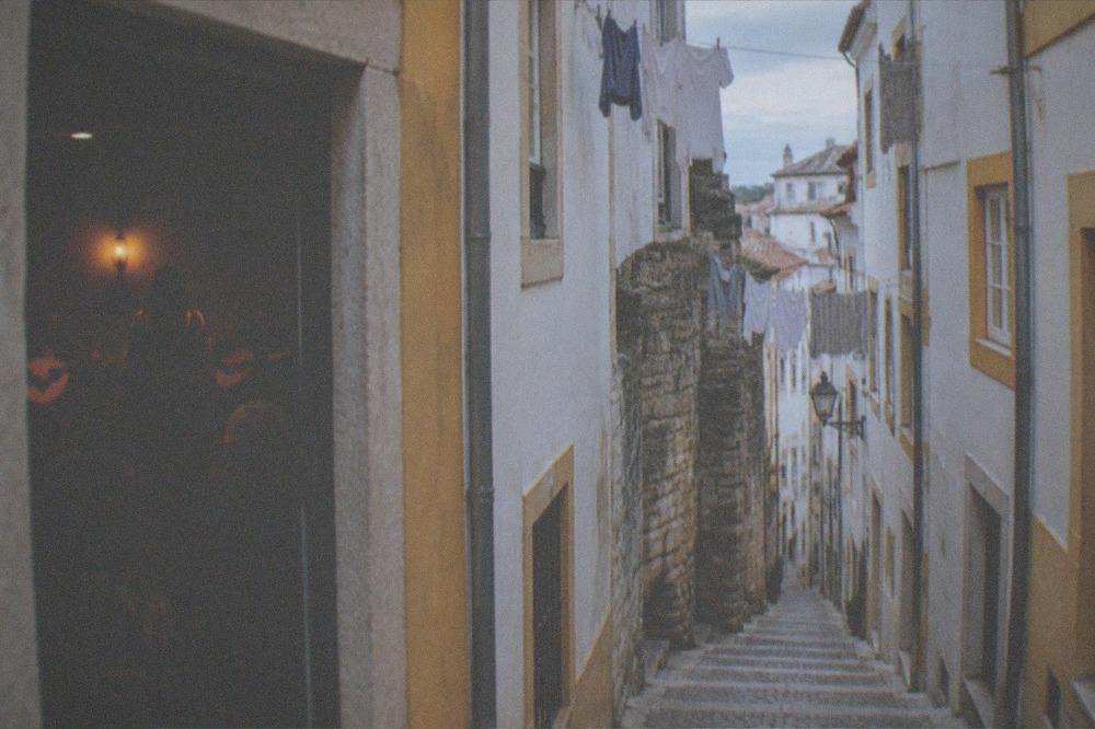 A fado performance in a small dimly lit room with a singer and guitarists