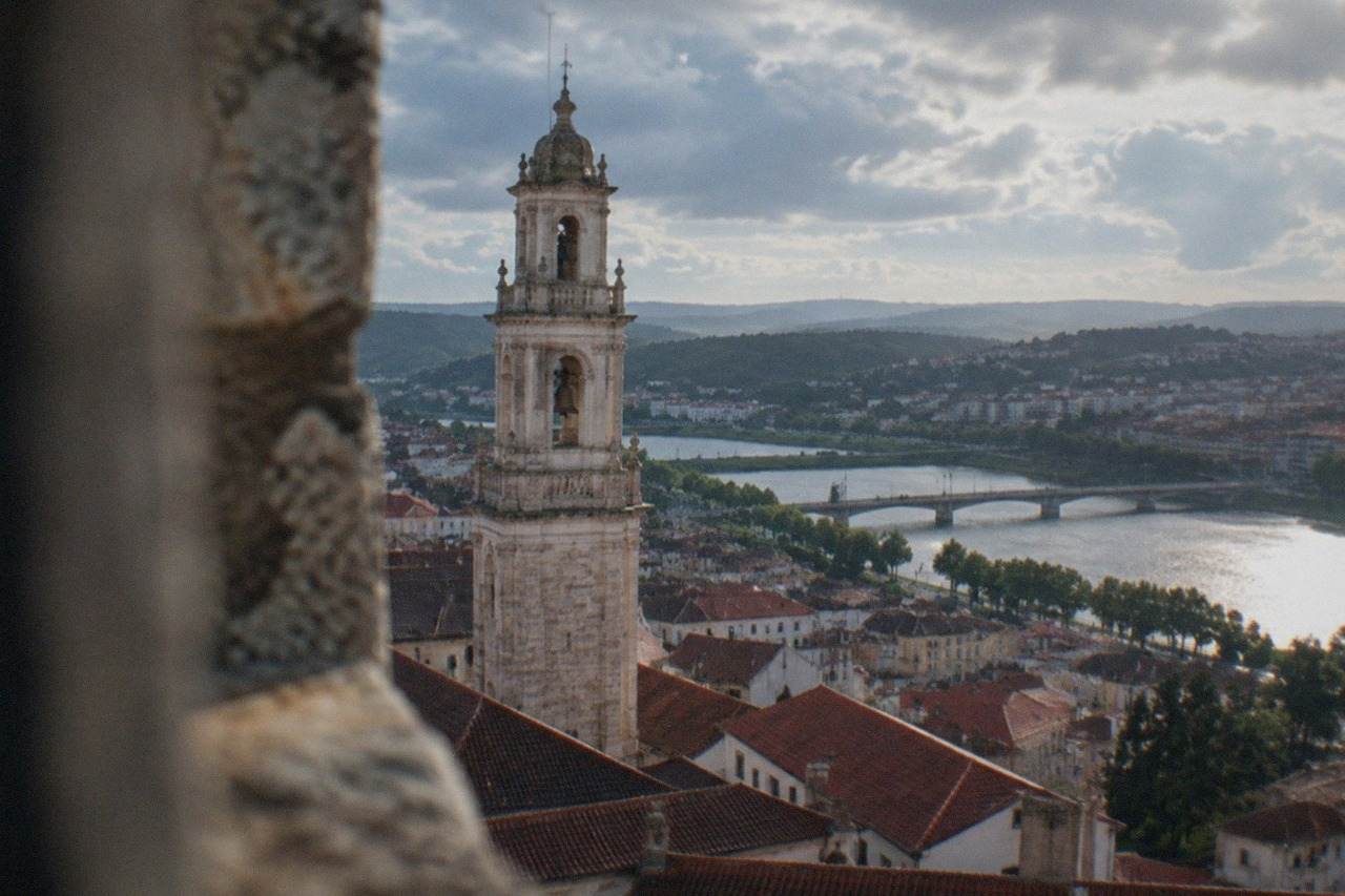 View over Coimbra's old town with the university tower rising above red rooftops and the River Mondego
