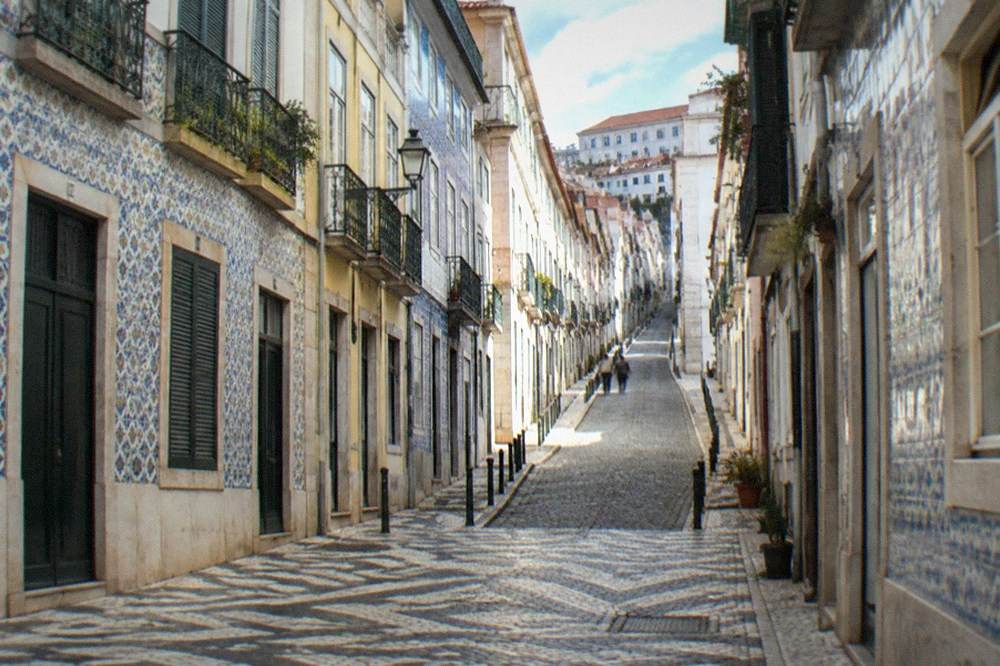 A steep cobbled street rising from the lower town toward the upper town of Coimbra