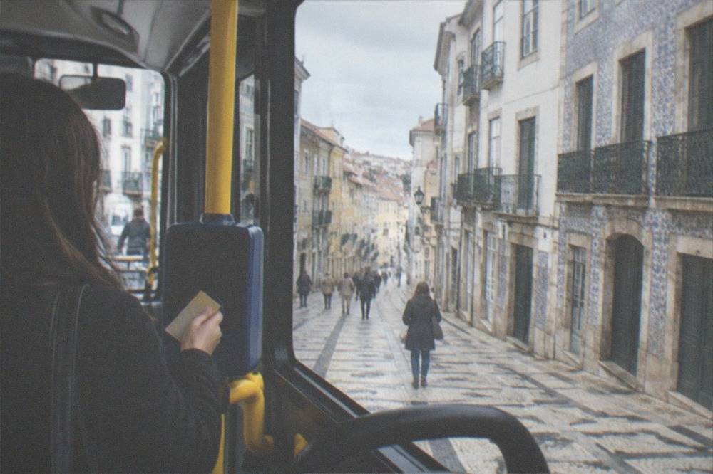 A passenger validating a public transport ticket on a city bus in Portugal