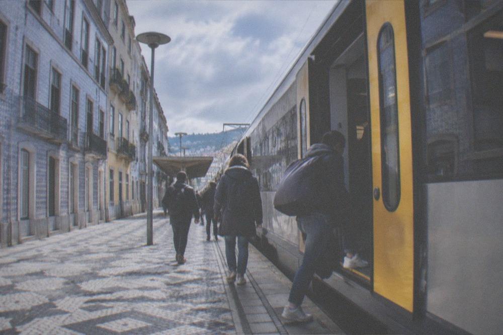 A regional train waiting at a platform in Coimbra with passengers boarding